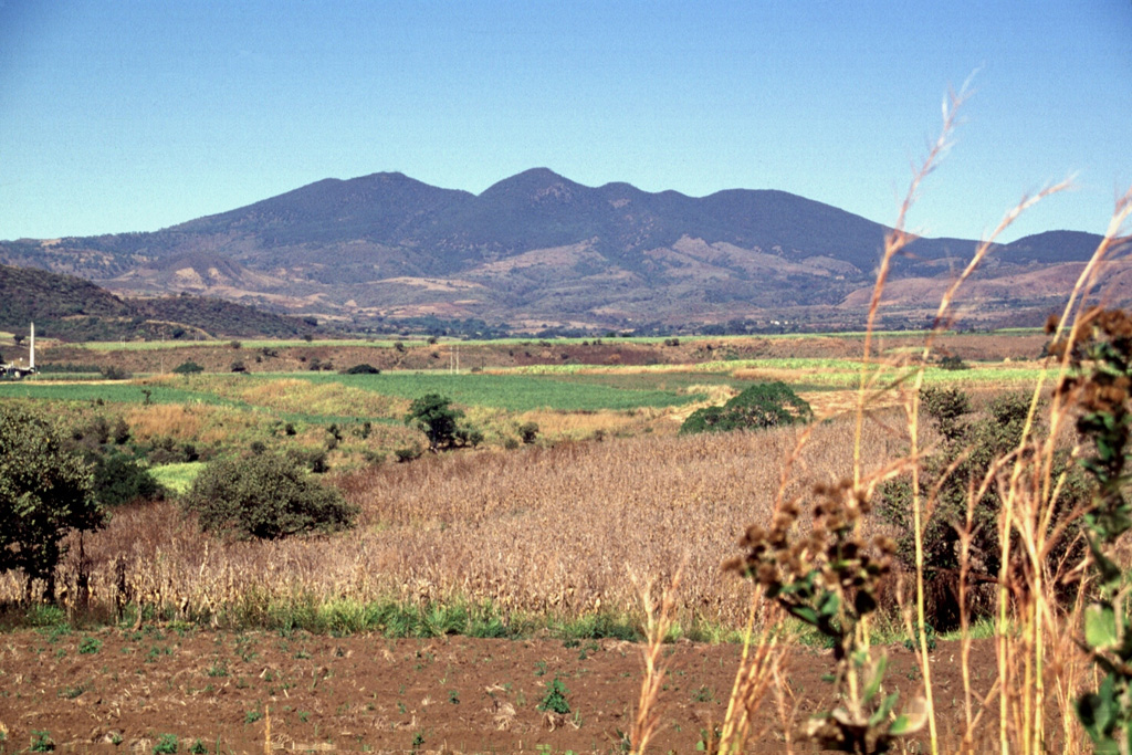The irregular ridge on the horizon is the SE rim of the compound 5-km-wide Tepetiltic caldera.  The NE caldera was offset from the center of the stratovolcano and its rim is lower to the NE (right).  The flanks of the andesitic-dacitic stratovolcano are blanketed by deposits of rhyodacitic ash and pumice from the caldera-forming eruptions.  Cinder cones on the NW and SE flanks of the volcano erupted alkalic lava flows.   Photo by Lee Siebert, 1997 (Smithsonian Institution).