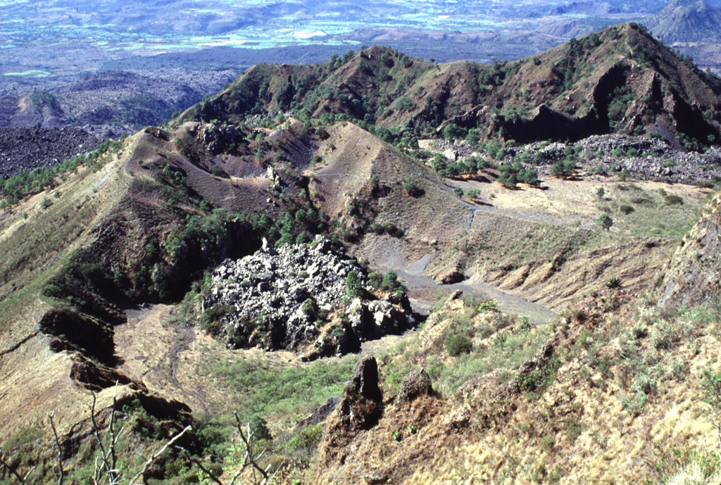 The small lava dome on the floor of the crater in the foreground was emplaced late in the 1870-75 eruption of Ceboruco. Levees of a lava flow that traveled 6.5 km down the west flank are higher than this crater, indicating that the main 1870 vent that fed the flows was probably located above the dome. The ridge to the upper right is the NW rim of the outer caldera. Photo by Lee Siebert, 1997 (Smithsonian Institution).
