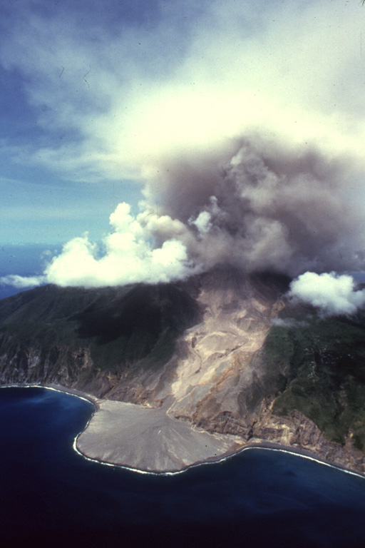 A diffuse ash column rises above the summit of Soufrière Hills volcano on April 2, 1997.  The prominent delta seen in this aerial view from the NE was created by pyroclastic flows that descended to the eastern coast down the Tar River valley.  The pyroclastic flows were produced by periodic collapse of a lava dome growing in the summit crater, which is breached to the east.  The eruption began in July 1995; pyroclastic flows first reached the sea a year later.  Copyrighted photo by Stephen O'Meara, 1997.