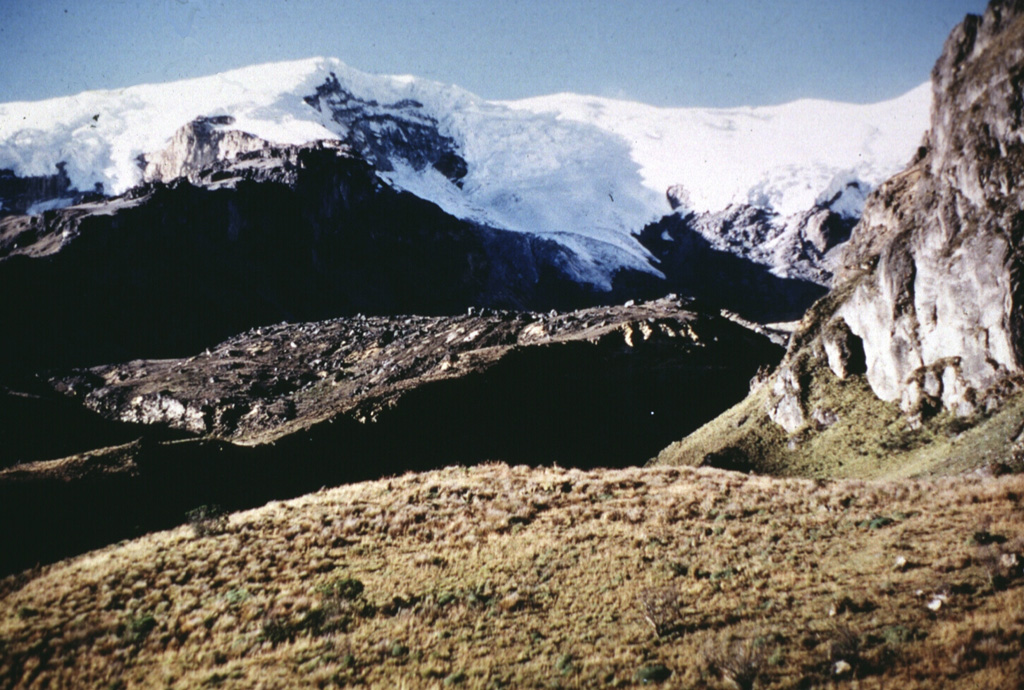 The glacier on Nevado del Ruiz is seen here above the Azufrado valley on the NE flank. Debris avalanche deposits from an eruption roughly 3,100 years ago, and from the 1595 eruption, appear in the foreground. The major eruption about 3,100 years ago produced a large ashfall deposit, the debris avalanche, and associated lahars and pyroclastic surges. The 1595 eruption, the largest from Ruiz in historical time, was similar. Lahars in 1595 caused over 600 fatalities. Photo by Jean-Claude Thouret (Université Grenoble).