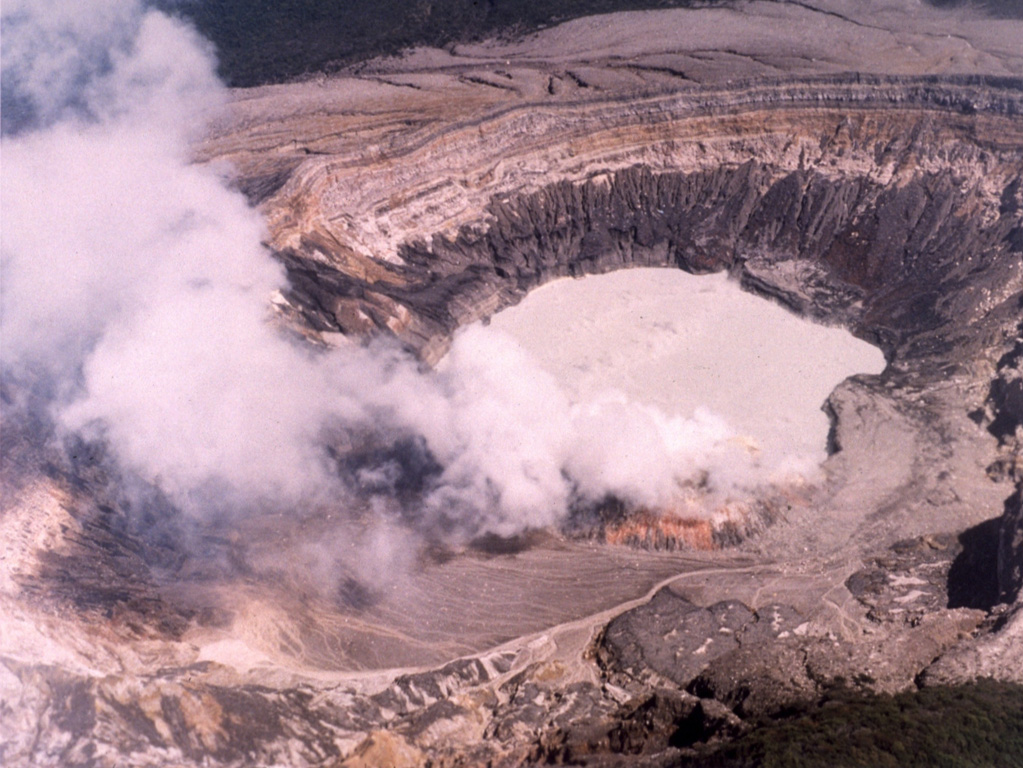 This February 1982 photo of the Poás active crater shows a gas plume rising from fumaroles on the southern crater rim. The northern crater wall in the background exposes pyroclastic deposits from phreatomagmatic and phreatic eruptions.  Photo by National Aeronautical and Space Administration (NASA), 1982.