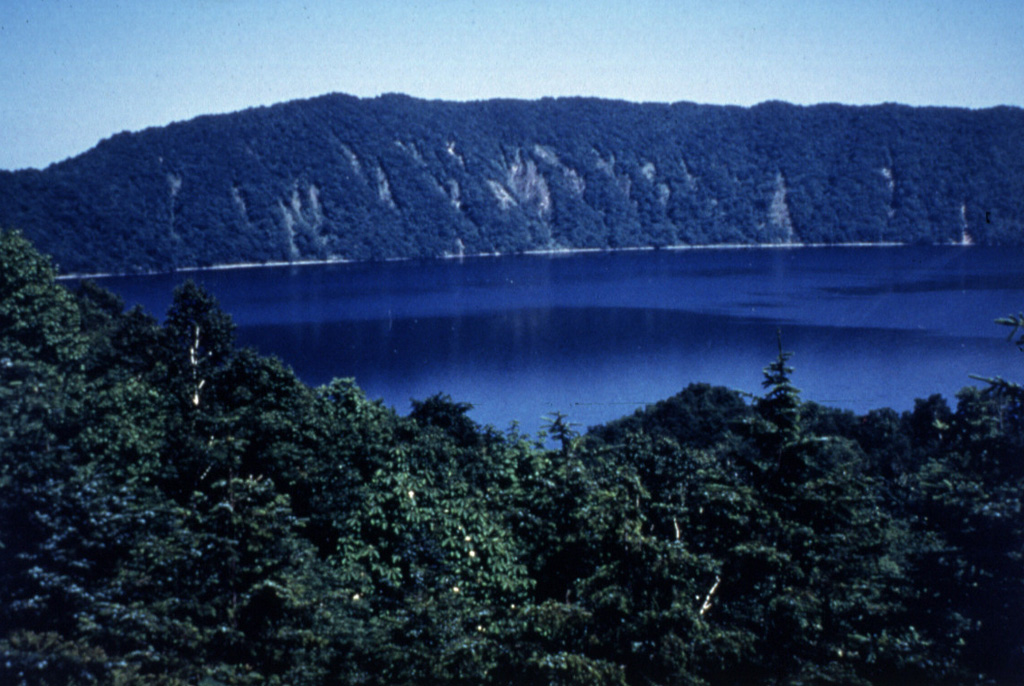 Lake Kuttara fills the 3-km-wide Kuttara caldera, which formed during major late-Pleistocene explosive eruptions. Pumice-rich pyroclastic flow deposits from this eruption cover a wide area around the volcano. Post-caldera volcanism constructed a group of explosion craters and a lava dome on the W flank. A phreatic explosion at one of the W-flank craters postdates the 1663 CE eruption of nearby Usu volcano. Photo by Mihoko Moriizumi, 1995 (Hokkaido University).