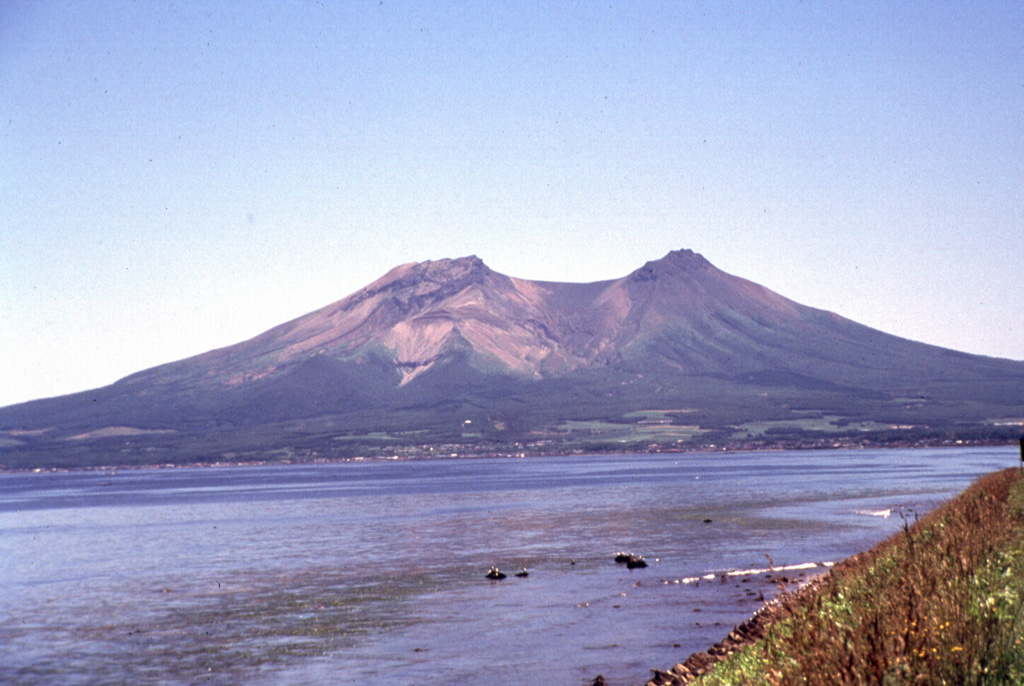 The two summit peaks of Komagatake, seen here from the NW, are remnants of a scarp formed by prehistoric flank collapse towards the NW. Several episodes of growth and collapse have occurred, with the most recent in 1640 when the flank collapsed towards the E. Photo by Mitsuhiro Yoshimoto, 1995 (Hokkaido University).