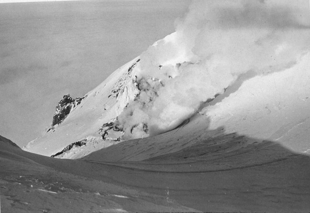 Steam rises on 7 April 1985 from a crater formed during a 6-9 January eruption, and ashfall darkens snow in the summit crater of Beerenberg volcano. An explosive and effusive eruption took place from a 1 km E-W fissure on NE flank near the tip of the island north of the 1970 eruption site. Lava flows reached the sea on the north side of the fissure. Photo courtesy of Nordic Volcanological Institute, 1985.