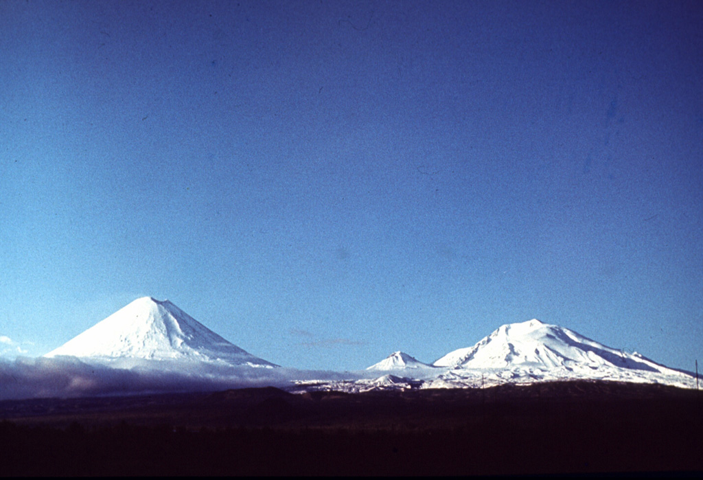 Symmetrical Klyuchevskoy and the eroded Ushkovsky edifice are seen here SW of the town of Klyuchi. The small Sredny cone, constructed on the eastern flank of Ushkovsky, occupies the saddle between them. Klyuchevskoy is one of Kamchatka's most active volcanoes and Ushkovsky has also erupted in historical time. Photo by Vera Ponomareva, 1975 (Institute of Volcanic Geology and Geochemistry, Petropavlovsk).