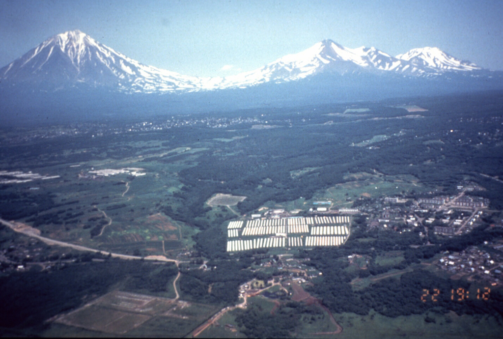 The Avachinskaya volcano group consists of a NW-SE-trending group of cones N of Petropavlovsk. Seen here from the western outskirts of the city with Koryaksky on the left, Avachinsky to the right-center, and Kozelskiy cone to the far right.  Photo by Vera Ponomareva, 1996 (Institute of Volcanic Geology and Geochemistry, Petropavlovsk).
