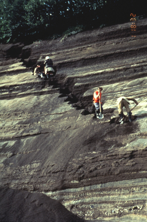 Volcanologists from the Institute of Volcanic Geology and Geochemistry in Petropavlovsk and the New Mexico Institute of Mining and Technology excavate a section through layered tephra deposits from Ilyinsky volcano in southern Kamchatka. Detailed study of the products of individual eruptions are used to determine the timing, frequency, and magnitude of those eruptions. The sequence of tephra layers shown here was deposited by explosive eruptions from Ilyinsky during the last 5,000 years. Photo by Phil Kyle, New Mexico Institute of Mining and Technology, 1996 (courtesy of Vera Ponomareva, IUGG, Petropavlovsk).