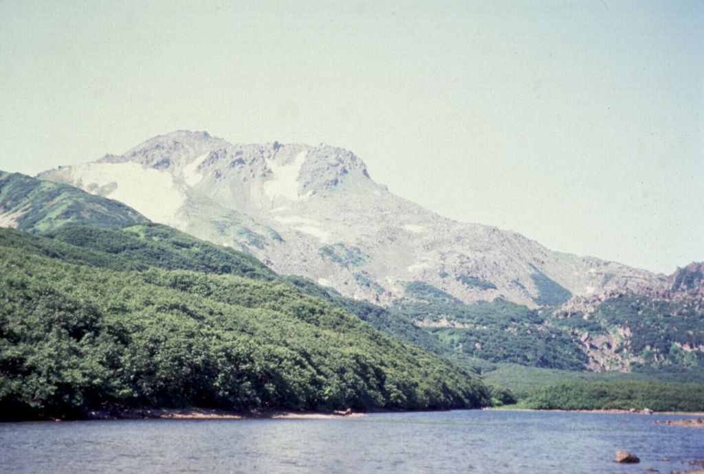 Diky Greben, seen here from the E along the Ozernaya River, is a Holocene lava dome complex that formed in the center of the 20 x 25 km Pleistocene Pauzhetka caldera. Early activity took place around 6,000 years ago. There are thick lava flows N and S of Nepriyatnaya dome (left-center horizon), which forms the summit of the complex.  Photo by Oleg Dirksen, 1996 (Institute of Volcanology, Petropavlovsk).