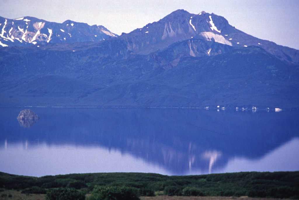 The Diky Greben lava dome complex rises above Kurile Lake caldera. Early eruptions took place about 6,000 years ago, about 2,000 years after formation of the 10-km-wide caldera. The eastern lava dome, seen here, opens to the E. Most of the edifice, including the unvegetated thick lava flow visible to the S (left) of the summit, was constructed about 2,000-1,500 years ago. Photo by Nikolai Smelov, 1996 (courtesy of Vera Ponomareva, Institute of Volcanic Geology and Geochemistry, Petropavlovsk).