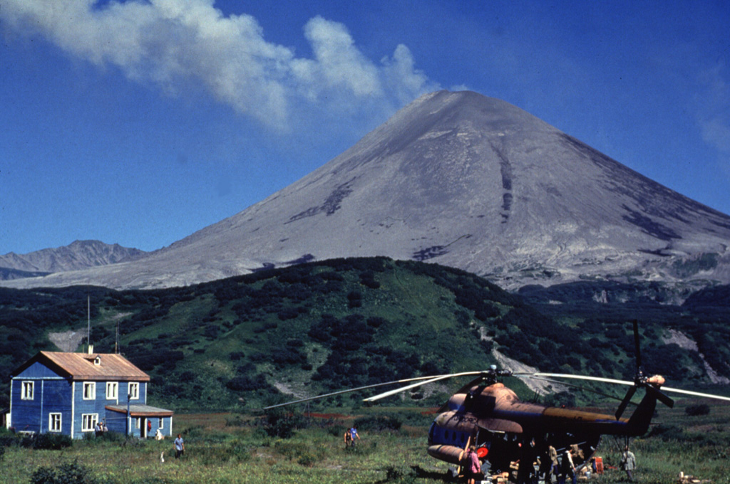 Karymsky was constructed within a 5-km-wide caldera that formed during a major explosive eruption about 7,500 years ago. Much of the cone is mantled by lava flows less than 200 years old, seen here from a volcanological field camp on the SW flank. Frequent historical eruptions have produced explosive activity with occasional lava flows from the summit crater. Photo by Nikolai Smelov, 1996 (courtesy of Vera Ponomareva, Institute of Volcanic Geology and Geochemistry, Petropavlovsk).