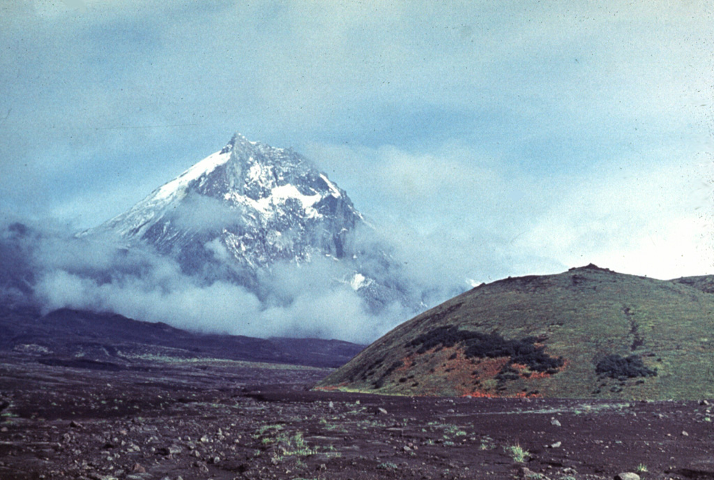 Kamen towers above the Karpinski scoria cone (left) on the ESE flank of Klyuchevskoy volcano with lahar deposits from Klyuchevskoy in the foreground. The eastern side of Kamen was removed by a massive volcanic landslide about 1,200 years ago. Photo by Vera Ponomareva, 1975 (Institute of Volcanic Geology and Geochemistry, Petropavlovsk).