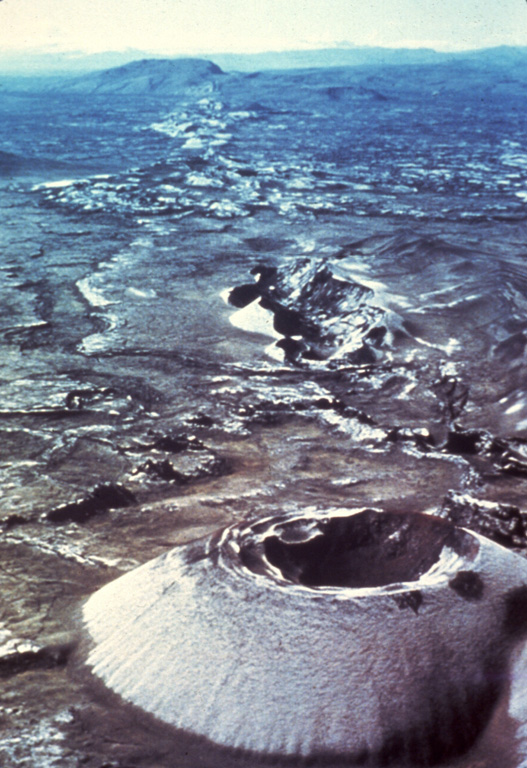 The most prominent of a series of fissures extending NE and SW from Grímsvötn central volcano is the noted Laki (Skaftár) fissure, which trends vertically across the photo SW of Grímsvötn and immediately SW of the Vatnajökull ice sheet. Laki produced the world's largest known historical lava flow during an eruption in 1783, as well as large volumes of gases but relatively little tephra. The approximately 27-km-long fissure is characterized by a sequence of craters and cones like that seen in the foreground. Photo by Sigurdur Thorarinsson (courtesy of Richard Williams, U.S. Geological Survey).