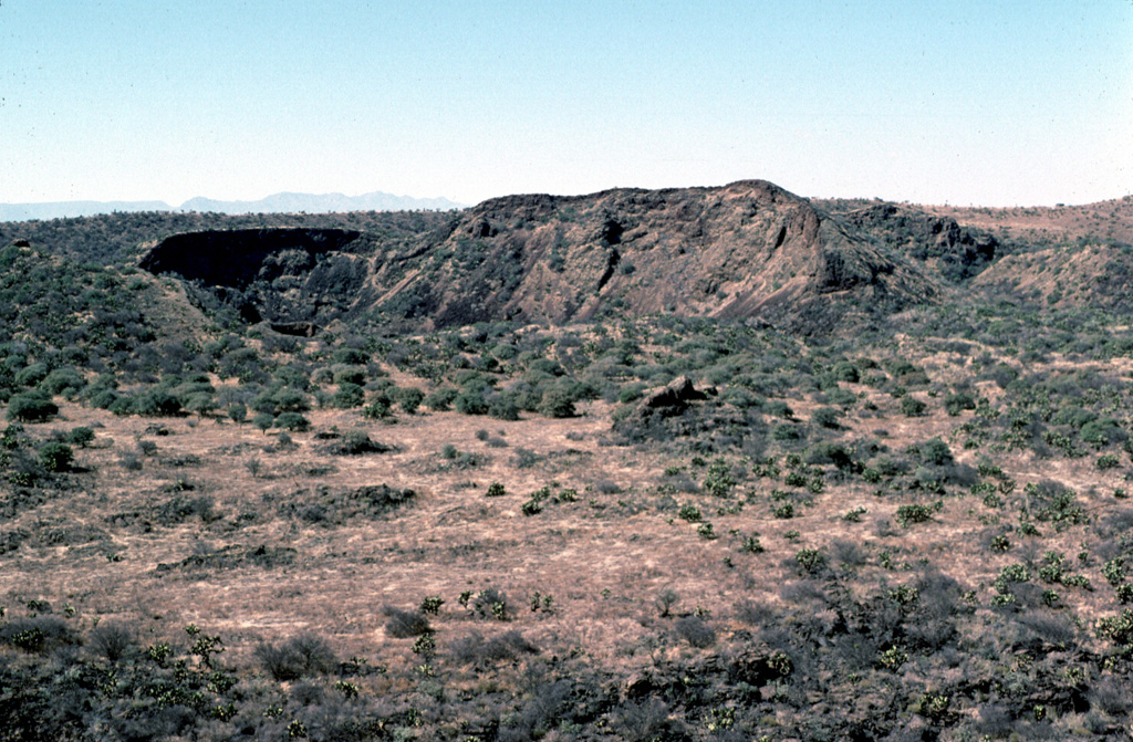 La Breña maar is seen here from the NE at the saddle between it and El Jagüey maar. The hill and crater at the center part of the photo are part of a cluster of nested cones formed on the floor of La Breña shortly after its formation. These post-maar eruptions produced Strombolian scoria and ash deposits due to less water being involved following the phreatomagmatic eruptions that created the maars. Photo by Jim Luhr, 1979 (Smithsonian Institution).
