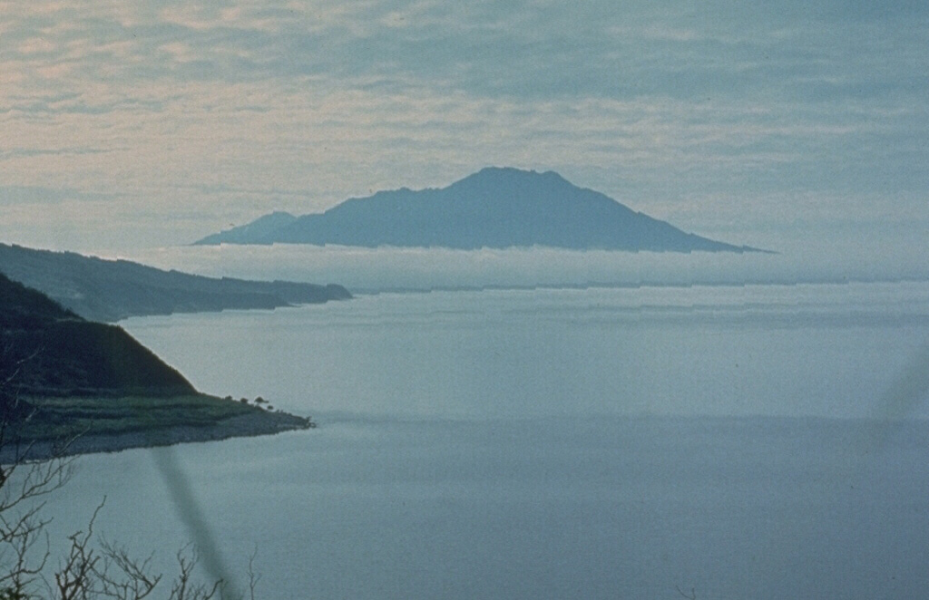 Etorofu-Atosanupuri forms a peninsula of Iturup Island and is seen here from the NE. A late-Pleistocene or early Holocene edifice formed an island that was later connected to Iturup. A 2-km-wide caldera was infilled by a cone that forms the present summit. Photo by A.Y. Antonov (courtesy of Oleg Volynets, Institute of Volcanology, Petropavlovsk).