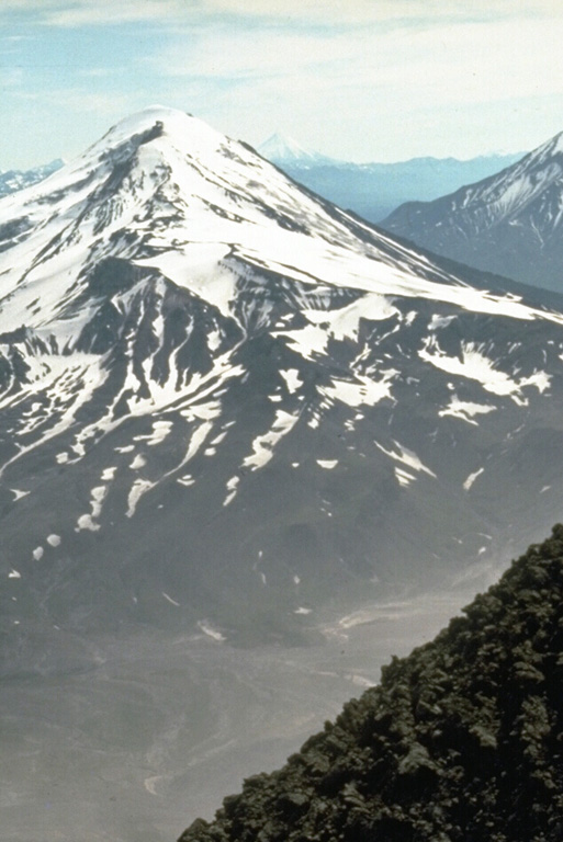 Ostraya and Ovalnaya Zimina form the Zimina volcanic complex north of Udina, which is at the SE end of the Klyuchevskaya volcano group. The larger Ovalnaya Zimina at the NW end of the complex has a large icecap, seen here from Bezymianny to the north.  Photo by Dan Miller, 1990 (U.S. Geological Survey).