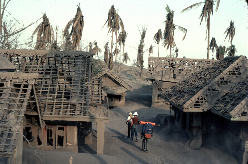 Heavy ashfall from explosive eruptions from Galunggung volcano in 1982 damaged or destroyed hundreds of houses, including these in a village near Kadong. The eruptions forced evacuation of 62,000 people living in densely populated areas near the volcano. Photo by Jack Lockwood, 1982 (U.S. Geological Survey).