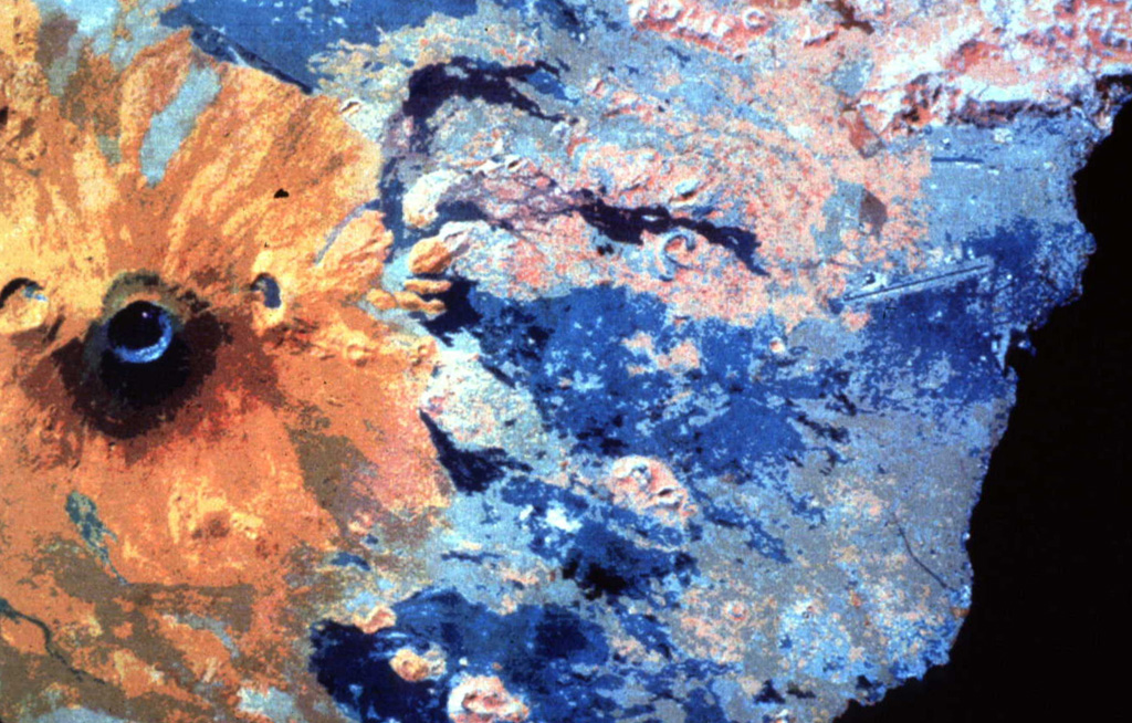 This false-color infrared image shows orange-colored Nyiragongo volcano at the left (north). The crater of the flank cone of Baruta can be seen to the left of the 1-km-wide summit crater. Darker-colored lava flows that mostly erupted from flank fissures extend south (right) to Lake Kivu, and several prominent orange-colored SW-flank scoria cones are visible. NASA Landsat image, 1994.