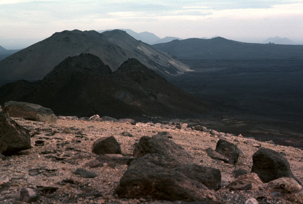 The eastern rim of the summit crater of Ketildyngja shield volcano overlooks flat-lying lavas of the Fremrinamur volcanic system on the right and steep-sloped Pleistocene subglacial lavas on the left. Photo by Michael Ryan, 1984 (U.S. Geological Survey).