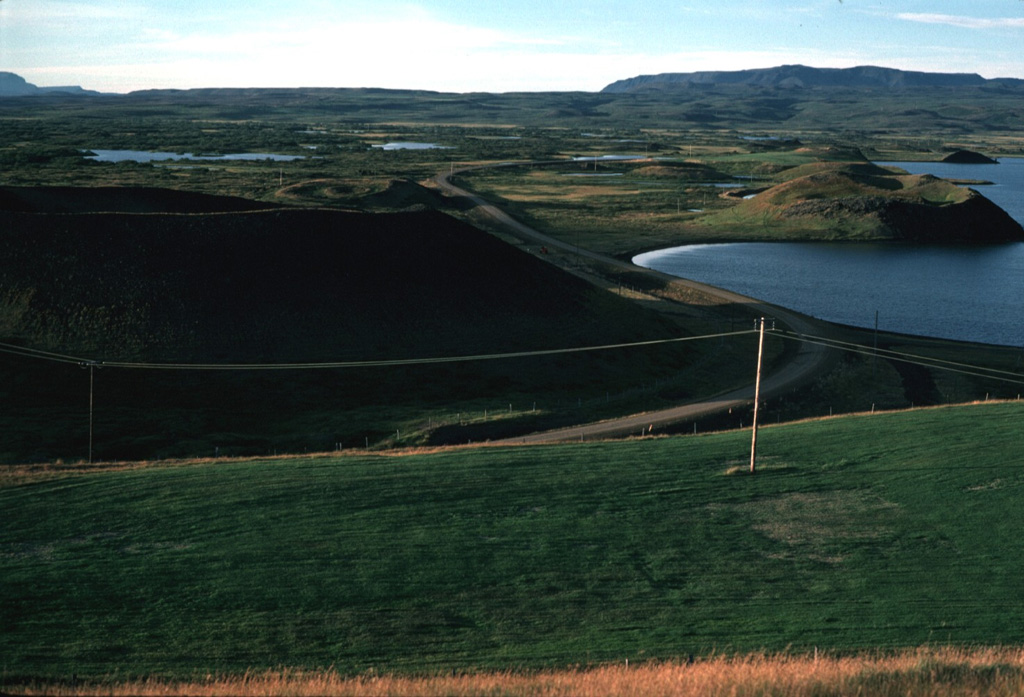 The Laxarhraun lava field in the Heiðarspordar volcanic system covered much of the Lake Mývatn area and lava flowed down the Laxardalur canyon to the north coast. Numerous pseudocraters and rootless cones, some of which are seen here along the shore of the lake, formed as a result of secondary explosive activity when the lava flow encountered abundant groundwater. The massive 224 km2 flow, erupted about 2,000 years ago, forms all but the northern shoreline of the lake. Photo by Michael Ryan, 1984 (U.S. Geological Survey).