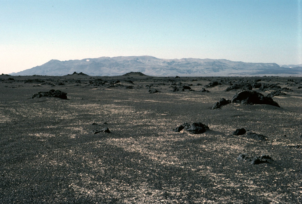 The Askja central volcano, seen here from the north, forms the Dyngjufjöll massif about 20 km N of the Vatnajökull icecap.  The massif is mainly composed of subglacial pillow lavas, lava flows, and hyaloclastites, with a broad summit truncated by three overlapping calderas. Much of the Holocene activity has been focused at and around this central massif, but the Askja volcanic system includes fissure swarms extending 170 km N. Photo by Michael Ryan, 1984 (U.S. Geological Survey).