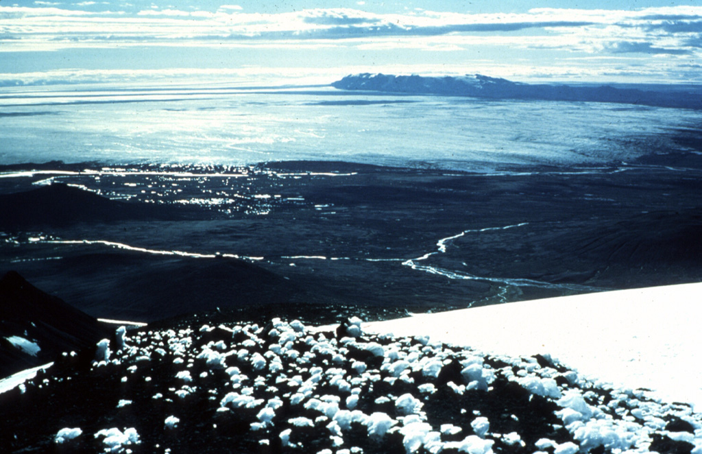The broad, relatively flat-topped and ice-covered summit of the Kverkfjöll volcano (upper right) is seen here from Snæfell mountain. This view looks WSW across the Bruarjökull glacier, an outflow sheet of the vast Vatnajökull icecap. Holocene lavas form the dark ridge extending across the horizon to the right from Kverkfjöll. Photo by Oddur Sigurdsson, 1978 (Icelandic National Energy Authority).