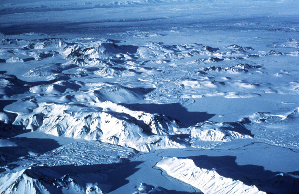 The Torfajökull central volcano is cut by a 12 x 18 km caldera that formed during the Pleistocene. Torfajökull is of one of the largest areas of silicic and intermediate volcanism in Iceland. The Laugahraun (lower left) and Domadalshraun (right center) lava flows, seen here from the SE, are located just within and north of, respectively, the northern caldera rim. At least 12 eruptions have occurred in the last 9,000 years with activity concentrated in the west. Photo by Oddur Sigurdsson, 1977 (Icelandic National Energy Authority).