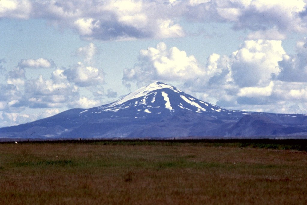 Hekla has a conical profile when viewed from the SW, looking directly down the axis of the elongated volcano. Axlargigur, the WSW end of the 5.5-km-long Heklugja fissure that crosses the summit, extends toward the photographer. This fissure was active along its entire length during the 1970 eruption. Photo by Bill Rose, 1980 (Michigan Technological University).