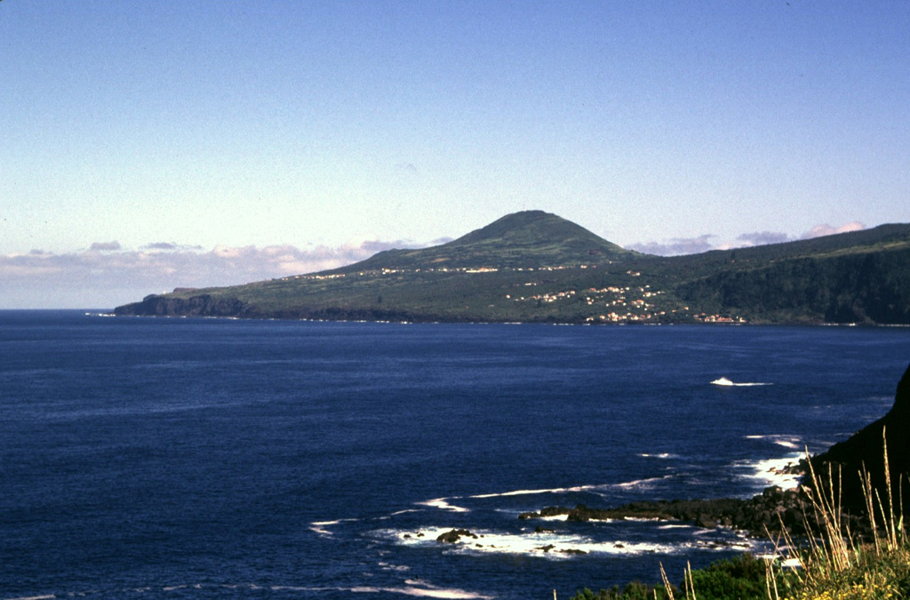 The gentle slope along the right horizon is covered by lava flows that formed during the 1672-73 eruption. This eruption occurred along a WNW-ESE-trending ridge forming a wedge-shaped peninsula at the western tip of the island. Cabeço Verde (center), seen here from the SE, is one of a chain of pyroclastic cones that were constructed along the axis of the peninsula during the eruption. The most recent eruption at Fayal started in 1957 and occurred at the end of this peninsula. Photo by Rick Wunderman, 1997 (Smithsonian Institution).