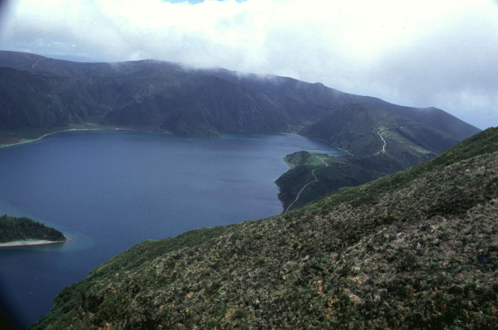 The inner Agua de Pau caldera, seen here from the western caldera rim, is now partially filled by Lagoa do Fogo caldera lake. The caldera was the source of a major explosive eruption about 4,600 years ago that deposited tephra layer Fogo A, and marked the renewal of explosive activity within the approximately 12,000-year-old caldera. The eruption also produced massive pyroclastic flows across most of the volcano’s flanks. Photo by Rick Wunderman, 1997 (Smithsonian Institution).