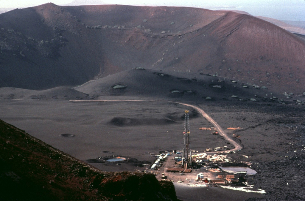 This geothermal drilling platform was part of an exploration program during the 1970's in Lanzarote's "Mountains of Fire."  Residual heat from the 18th-century eruptions remains.  Temperatures of 100 degrees centigrade were reached only a few cm below the surface, and a maximum temperature of 312 degrees was measured at a depth of 12 m. Copyrighted photo by Katia and Maurice Krafft, 1977.