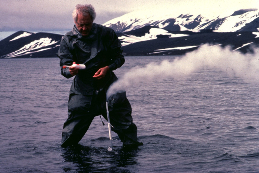 French volcanologist Jean-Louis Cheminée samples volcanic gases from a shallow submarine fumarole in the caldera of Deception Island.  The temperature of the fumarole varied from 100 to 200 degrees Centigrade. Copyrighted photo by Katia and Maurice Krafft, 1984.