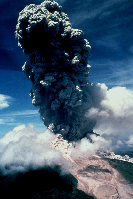 An ash cloud towers above Soufrière Hills in October 1997 as pyroclastic flows descend the volcano's flanks.  This was one of a series of 61 explosive eruptions that occurred during a period of high activity between September 28 and October 21.  Explosions occurred at an average interval of 8.5 hours.  The largest explosions, October 20-21, produced eruption columns to heights of 9 km.  Pyroclastic flows accompanying many of the explosions traveled down all sides of the volcano, but were preferentially directed to the north. Photo by Peter Francis, 1997 (Open University).