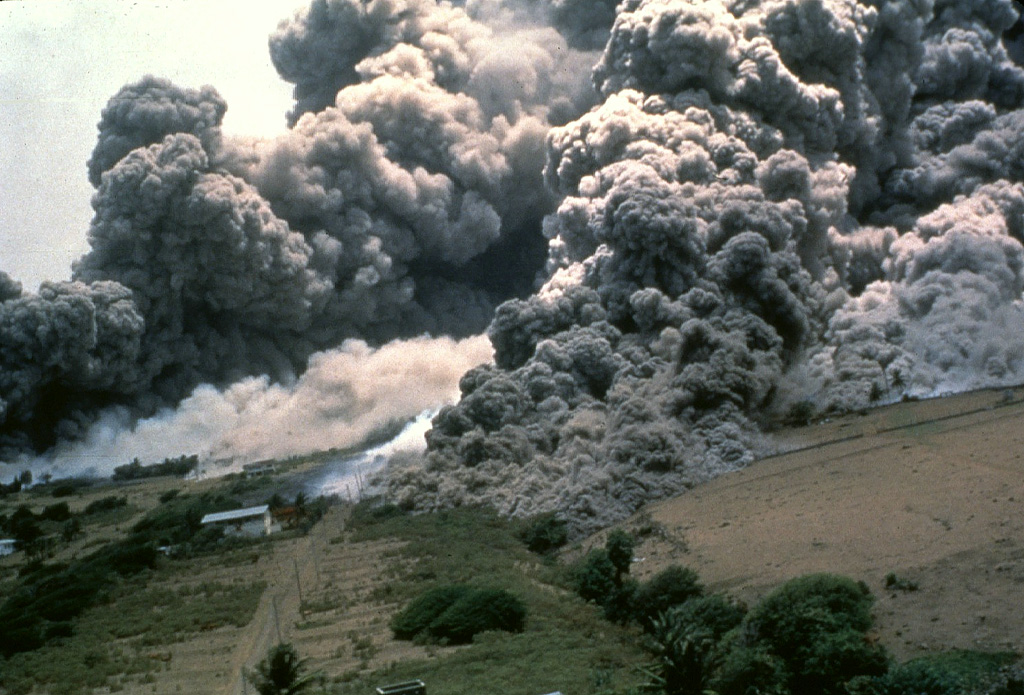 Pyroclastic flows sweep down the NE flank of Soufrière Hills volcano in December 1997 towards the abandoned airport.  During 1997, pyroclastic flows reached the coast of the island on the NE, SW, and western sides.  The former capital city of the island, Plymouth, and many other villages were overrun by these high-temperature pyroclastic flows. Photo by Peter Francis, 1997 (Open University).