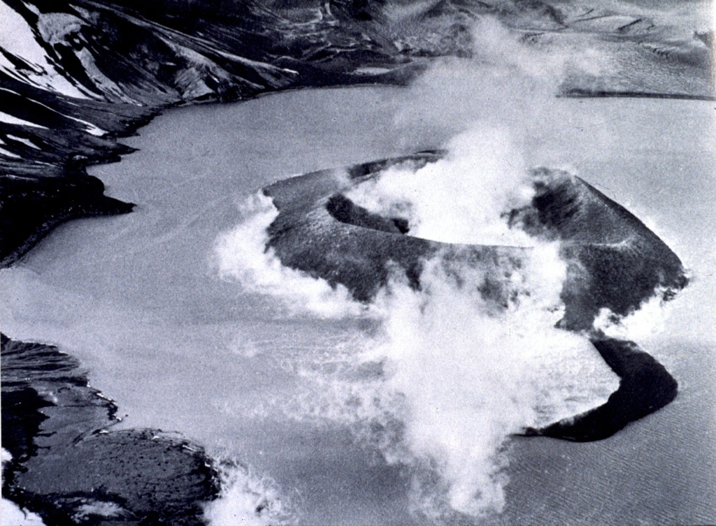 Steam rises above a new island formed during an eruption in Telefon Bay at Deception Island during 4-7 December 1967. The eruption occurred from four vents along a NE-SW line cutting across the bay, building an approximately 1-km-long, 62-m-high island which was named Yelcho, after a research vessel that was there at the time. An eruption in 1970 occurred at approximately the same location, destroying much of Yelcho, and incorporating the remnants onto a new stretch of land attached to the inner caldera wall.  Photo by the Chilean Navy, 1967 (published in González-Ferrán, 1995).