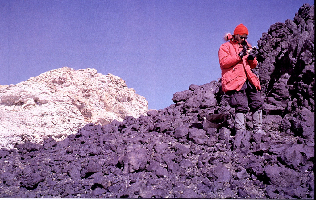 A geologist examines lava flows west of the 4.5-km-wide summit caldera of Mount Andrus. This volcano is the youngest of three N-S-trending volcanoes in the Ames Range of western Marie Byrd Land, Antarctica.  Photo by Oscar González-Ferrán (University of Chile).