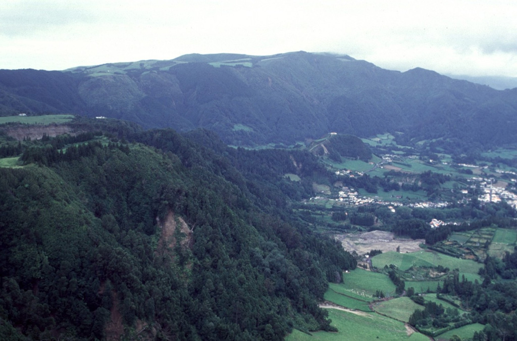 The village of Furnas (right) lies in the center of Furnas caldera, whose northern rim forms the ridge in the background. The largest eruption in the last 5,000 years originated at a vent where the village is now located. This Plinian eruption, named Furnas C, occurred about 1,900 years ago. Activity varied between phreatomagmatic and magmatic styles, producing massive fallout of pumice and ash and pyroclastic flows and surges. Photo by Rick Wunderman, 1997 (Smithsonian Institution).