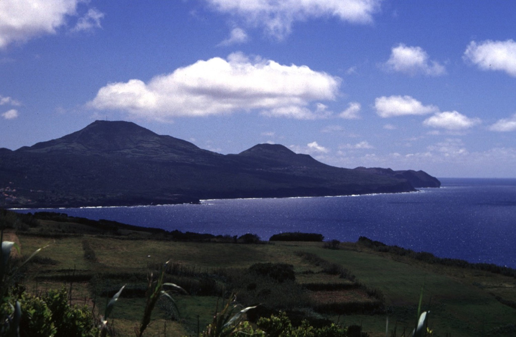 Cabeço Verde (left center) and Cabeço do Canto (center) are two pyroclastic cones along a linear chain of volcanoes that form the western peninsula of Fayal Island. Lava flows from these cones flowed into the sea on the northern and southern coasts during the 1672-73 eruption.  Photo by Rick Wunderman, 1997 (Smithsonian Institution).