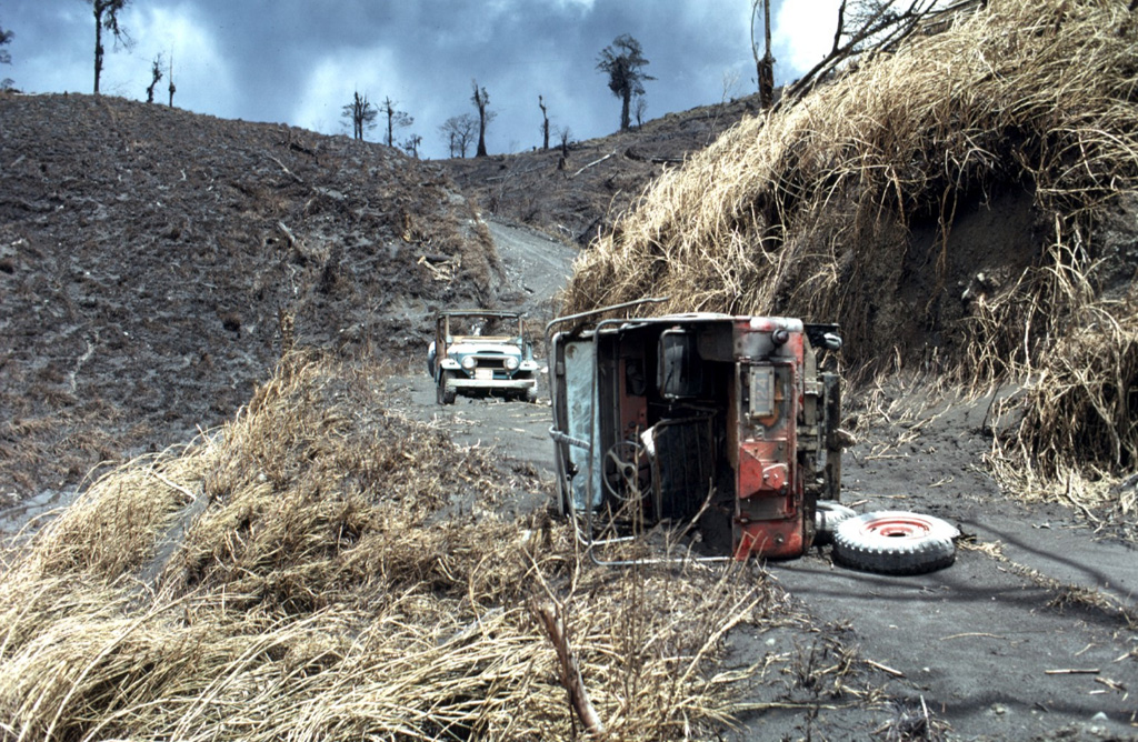 The jeep in the foreground was overturned by pyroclastic flows on 31 July 1968, during a major explosive eruption of Arenal. The 8-10 people who died on this date were within the devastated zone in the background to recover the bodies of people killed by the powerful 29 July eruptions.  Photo by William Melson, 1968 (Smithsonian Institution).