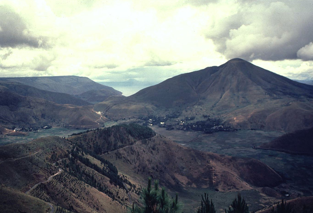 Clouds rise above the summit of Pusukbukit (right), a post-caldera cone constructed just inside the western rim of Toba caldera. Lake Toba, which fills the caldera, is visible beyond the northern (left) flank of Pusukbukit.  Photo by Bill Rose, 1982 (Michigan Technological University).