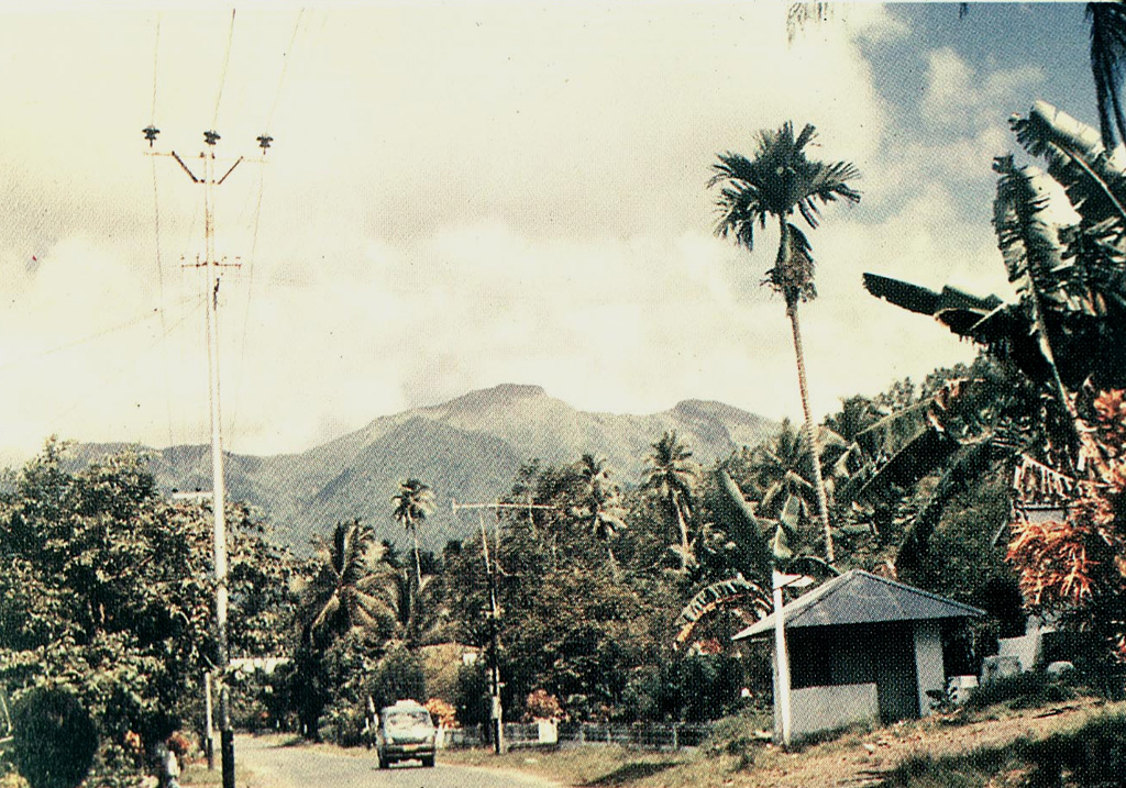 Gunung Awu volcano, one of the deadliest in Indonesia, looms above the village of Bungalawang.  Deep valleys that form passageways for lahars dissect the flanks of the 1320-m-high volcano, which was constructed within a 4.5-km-wide caldera.  Powerful explosive eruptions in 1711, 1812, 1856, 1892, and 1966 produced devastating pyroclastic flows and lahars that caused more than 8000 fatalities.   Photo by S. Dirasutisna, 1990 (Volcanological Survey of Indonesia).