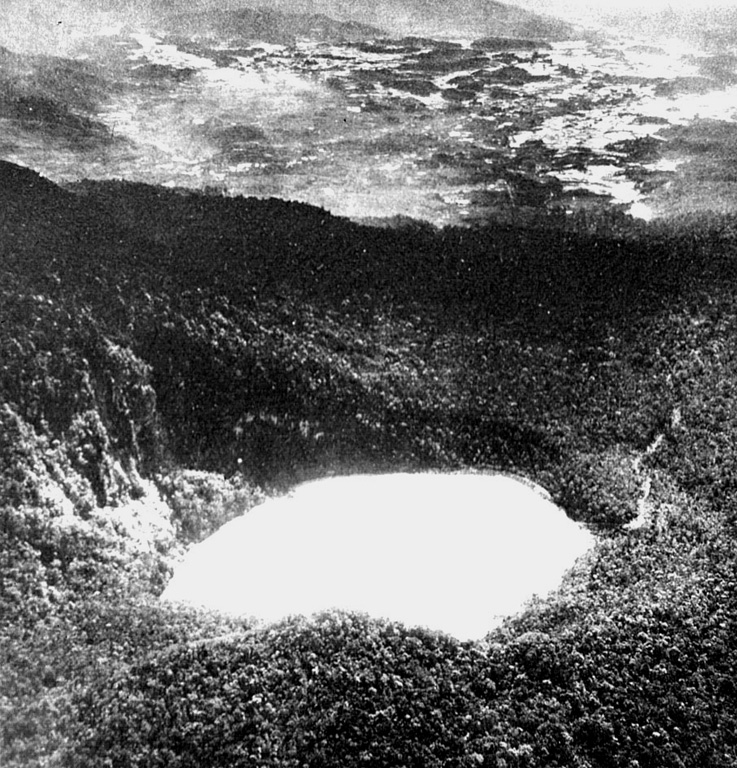 Kawah Putih is the SE-most of two summit craters at Gunung Patuha. This view from the SW shows the Bandung plain in the distance. The lake-filled Kawah Putih is 3-3.5 km wide and 180 m deep, and is mined for sulfur. Photo published in Taverne, 1926 