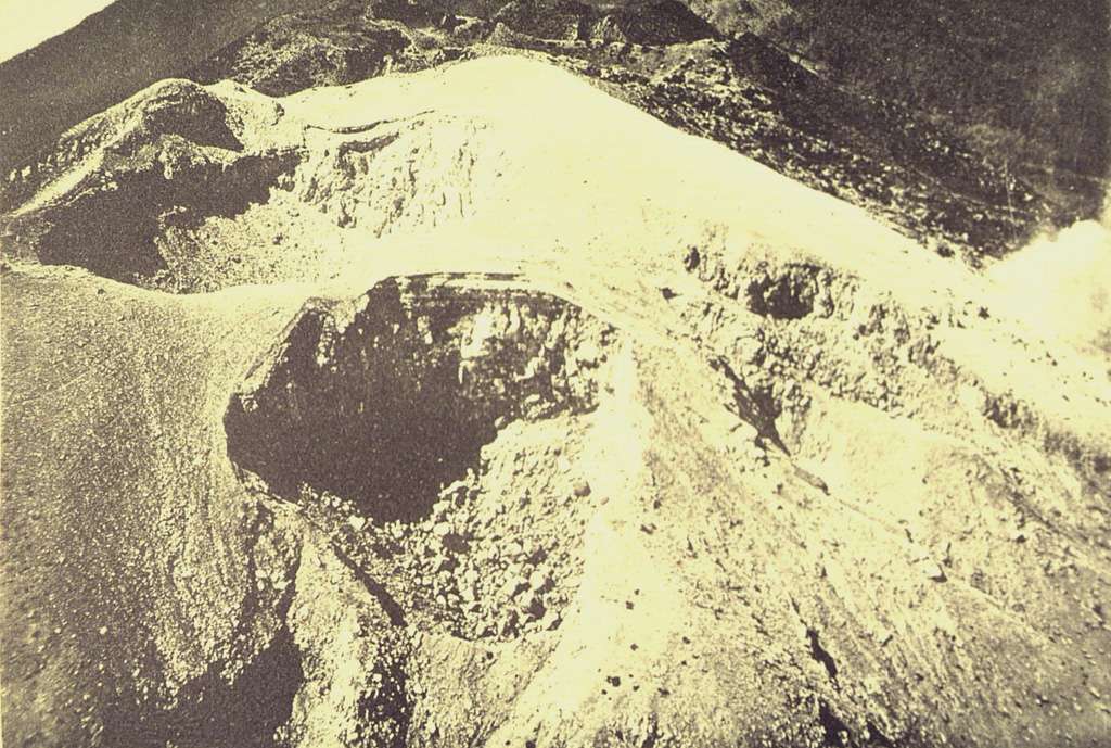 A complex cluster of craters at the summit of Gunung Welirang. Kawah Jero crater (upper left) lies behind Tilas Geni crater in the foreground, and Kawah Plupuh is to the right. This view looks from the north to craters of Gunung Arjuno in the background. Photo published in Taverne, 1926 