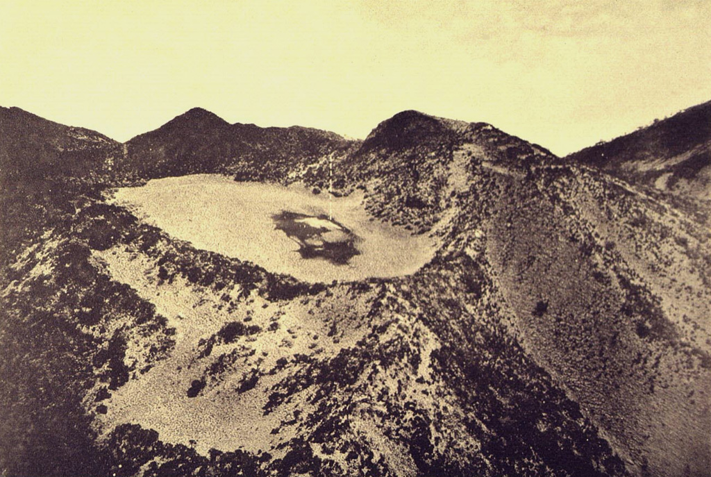 Kawah Kuning crater, at the summit of Gunung Lawu, is seen here in an aerial view from the west. The flat-floored, 250-m-wide crater is truncated by younger craters to the south. Photo published in Taverne, 1926 