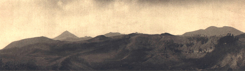 The Inielika chain of cones and craters stretches across the central highlands of Flores Island at right in this view from the NE. The peak at left center is Gunung Inierie volcano, the highest on the island. On the far left horizon is Wolo Bobo, a feature of the Bajawa cinder cone complex. The high irregular peak on the right horizon is part of the Lobobutu caldera wall, with various Inielika craters in the foreground. Photo published in Kemmerling 1929, 