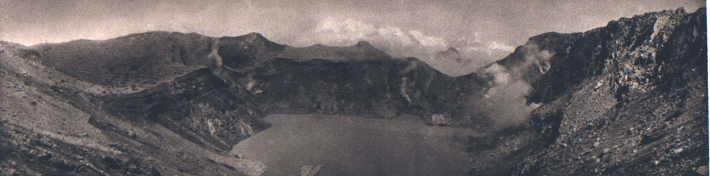The crater of Gunung Egon contains a shallow lake in this 1920's view from the E. Fumarole plumes rise from the shores of the lake, which occupies the 350-m-wide, 200-m-deep crater. Photo published in Kemmerling 1929, 