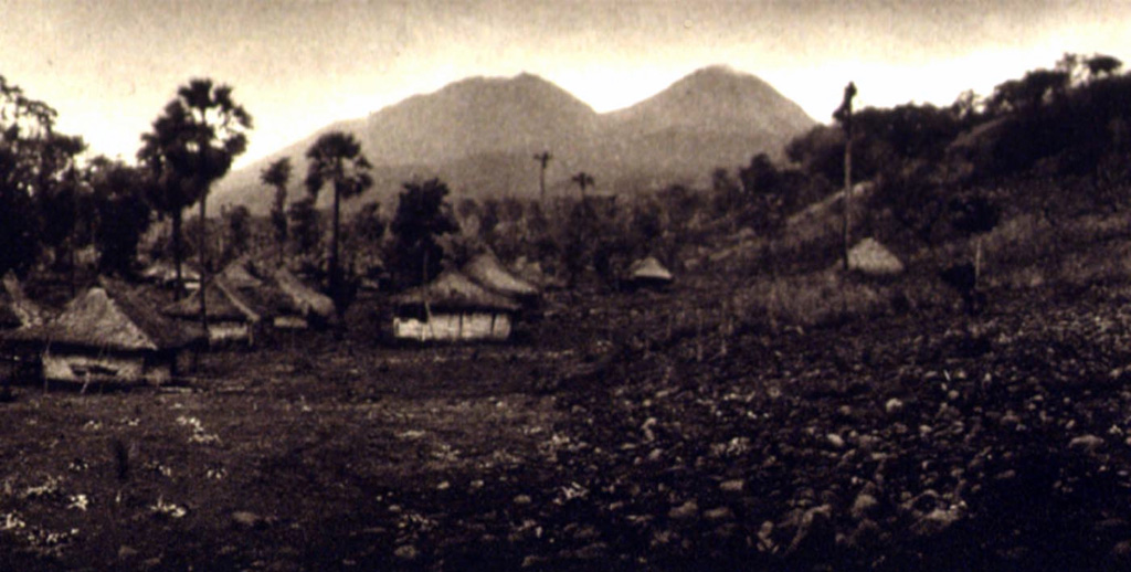 The NE flanks of Gunung Lewotobi rise above the village of Nobo. Lewotobi Perempuan (left) is located SW of Lewotobi Lakilaki (right). Both of these volcanoes have erupted during historical time, although Lakilaki has erupted much more frequently. Photo published in Kemmerling 1929, 