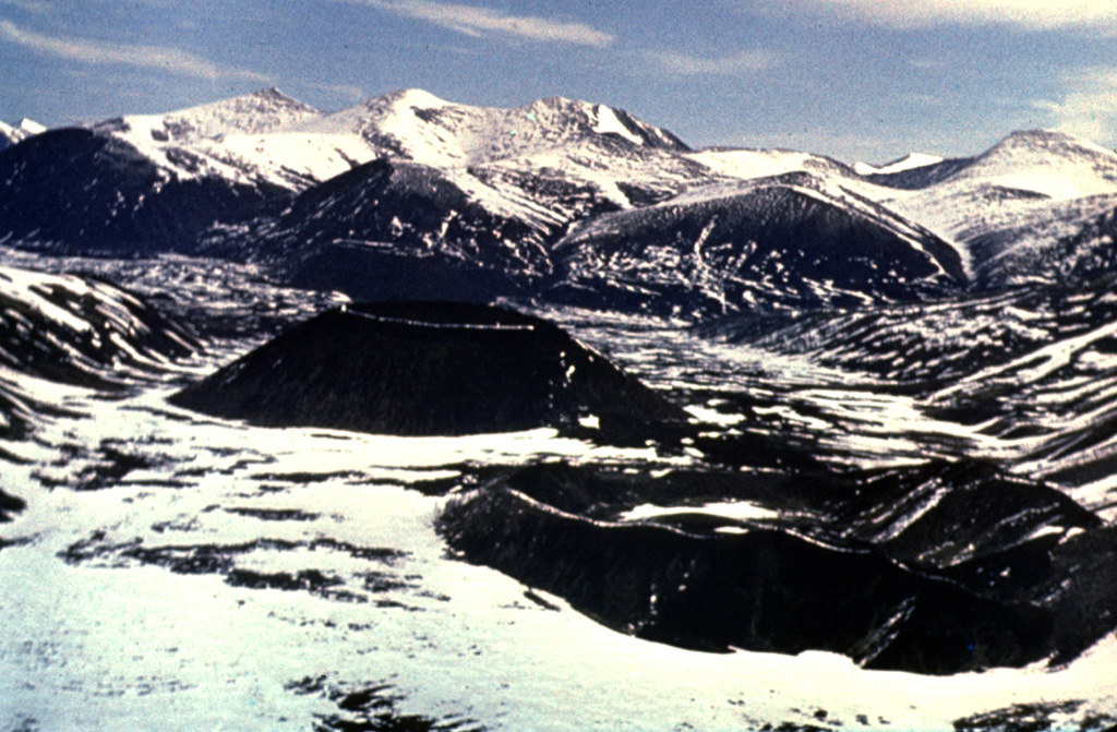A group of small basaltic scoria cones were erupted from the Jom-Bolok volcanic field near the Oka Plateau, about 200 km WNW of the SW tip of Lake Baikal. Two are seen here from the SE. The eroded cone to the lower right is Stariy. The young cone (near the center) is Peretolchin, named after a geologist who disappeared in the early 20th century, prior to the Russian revolution. This was the source of the voluminous 70-km-long Jon-Bolok lava flow, one of the world's longest Holocene lava flows. Photo by Sergei Rasskazov, 1995 (Siberian Branch, USSR Academy of Sciences).