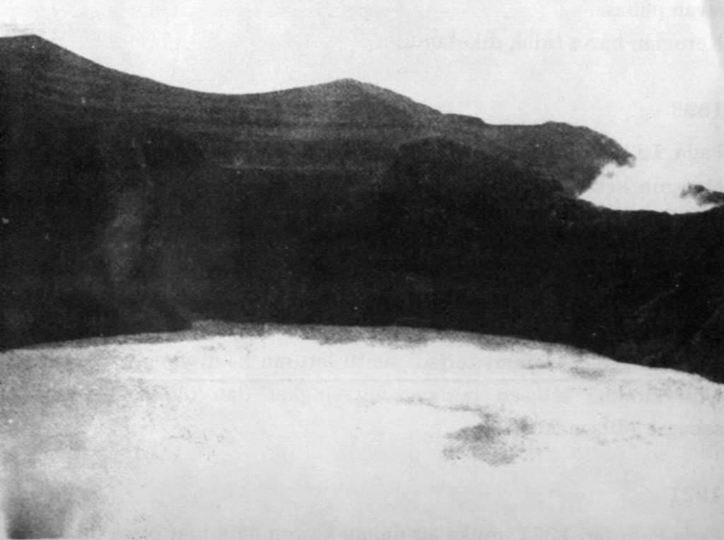This 1922 photo shows the roughly 825 x 1050 m wide, 150-m-deep crater lake of Awu volcano from the NW.  On June 20, 1922 the previously clear crater lake water was covered with a layer of sulfur.  A small gas eruption took place on July 23 and phreatic explosions continued during the following months.  Lake bottom surveys by Stehn in 1922 indicated that a lava dome had formed beneath the surface of the crater lake.  Dome growth was thought to have begun in 1921, when the lake level rose 3 m during a year of normal rainfall.   Photo courtesy of Volcanological Survey of Indonesia, 1922.