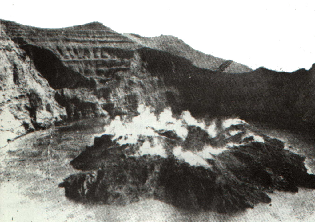 Steam rises from a newly erupted lava dome emplaced in 1931 in the crater lake of Awu volcano.  The crater lake water level and temperature rose beginning in December 1930, and continued into the next year, when rumblings, sulfur smell, and gas bubbles were observed.  Dull explosions and an eruption cloud were noted at the beginning of March 1931.  A lava plug appeared to be visible below the surface of the lake on April 7, breached the surface on April 18, and reached a height of 80 m by the end of the year. Photo courtesy of Volcanological Survey of Indonesia, 1931.