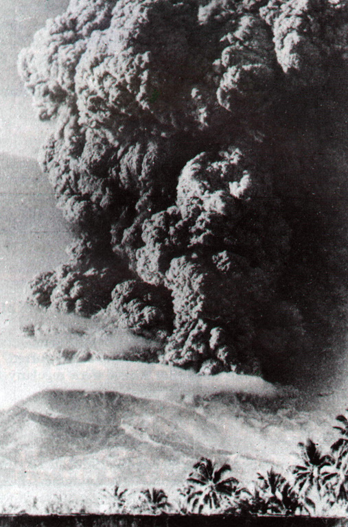 An ash plume rising above Iya is seen from Ende city on 27 January 1967. Iya erupted suddenly with no recognized precursory activity. The plume rose 5 km above the summit from a new 400-650 m wide crater on the upper SW flank, accompanied by a pyroclastic flow. Houses were damaged on the nearby island of Ende and one person was killed. Secondary lahars later caused another fatality in a village below the ash-covered cone of Raja. The eruption ended on 30 January. Photo by Go Ciap Cing, 1969 (courtesy of Volcanological Survey of Indonesia).